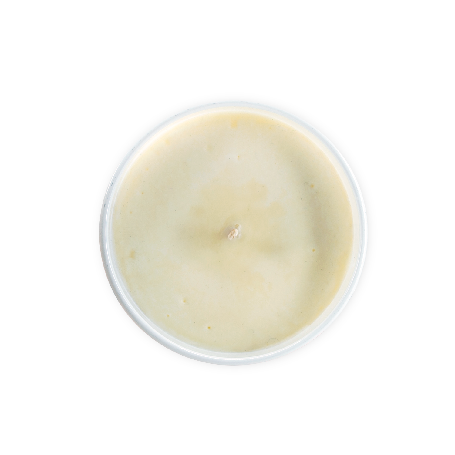 Overhead view of a white candle in round container on black background