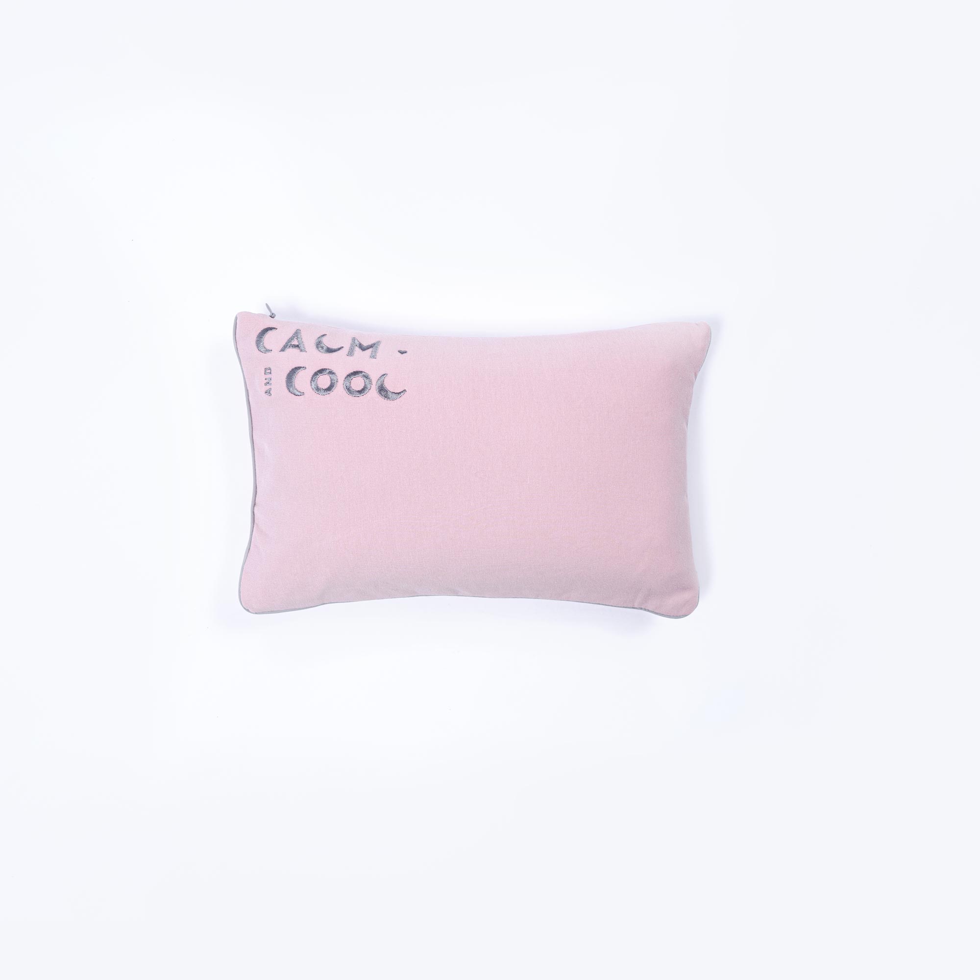 Pink pillow with calm and cool text on white background