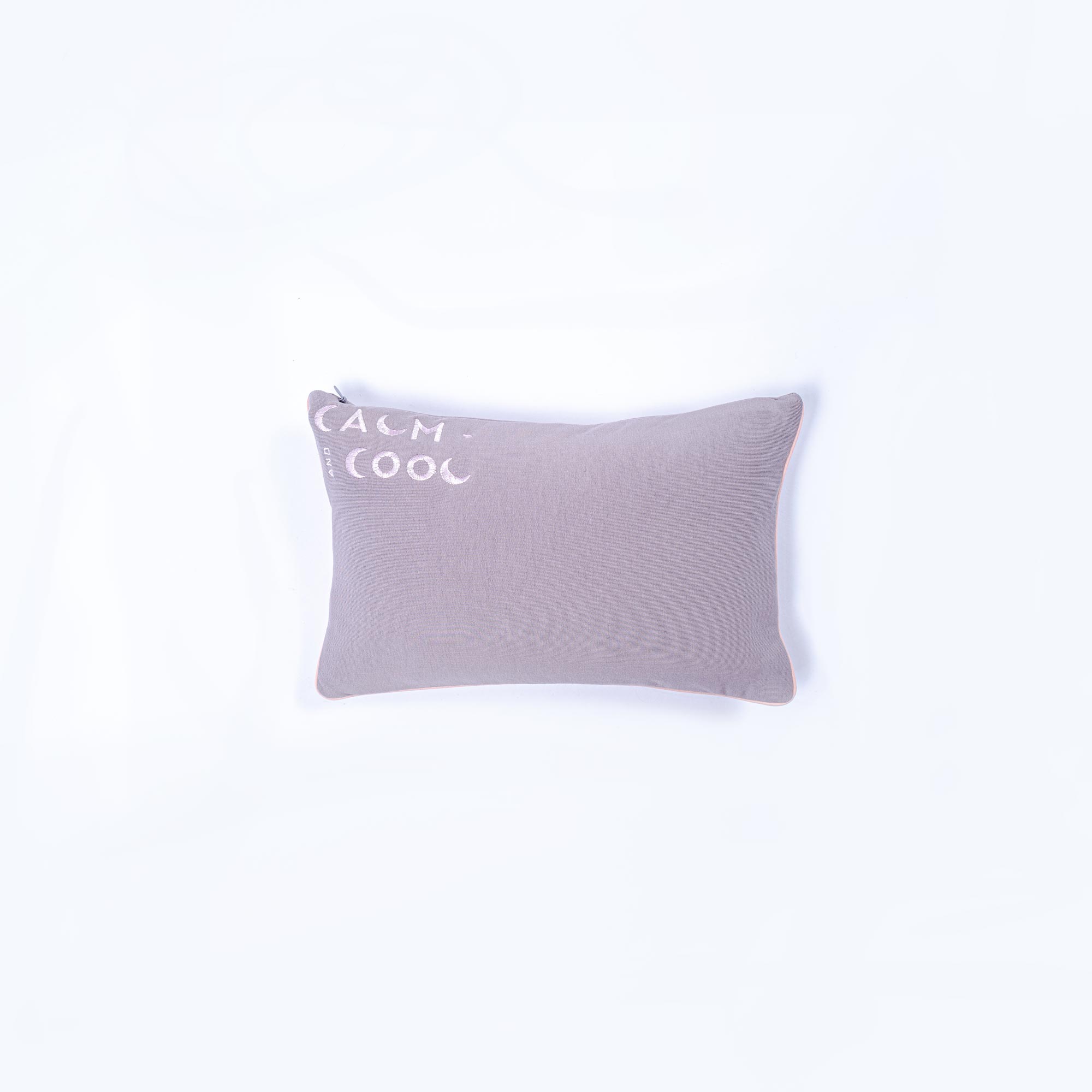 Gray pillow with calm and cool text on a white background