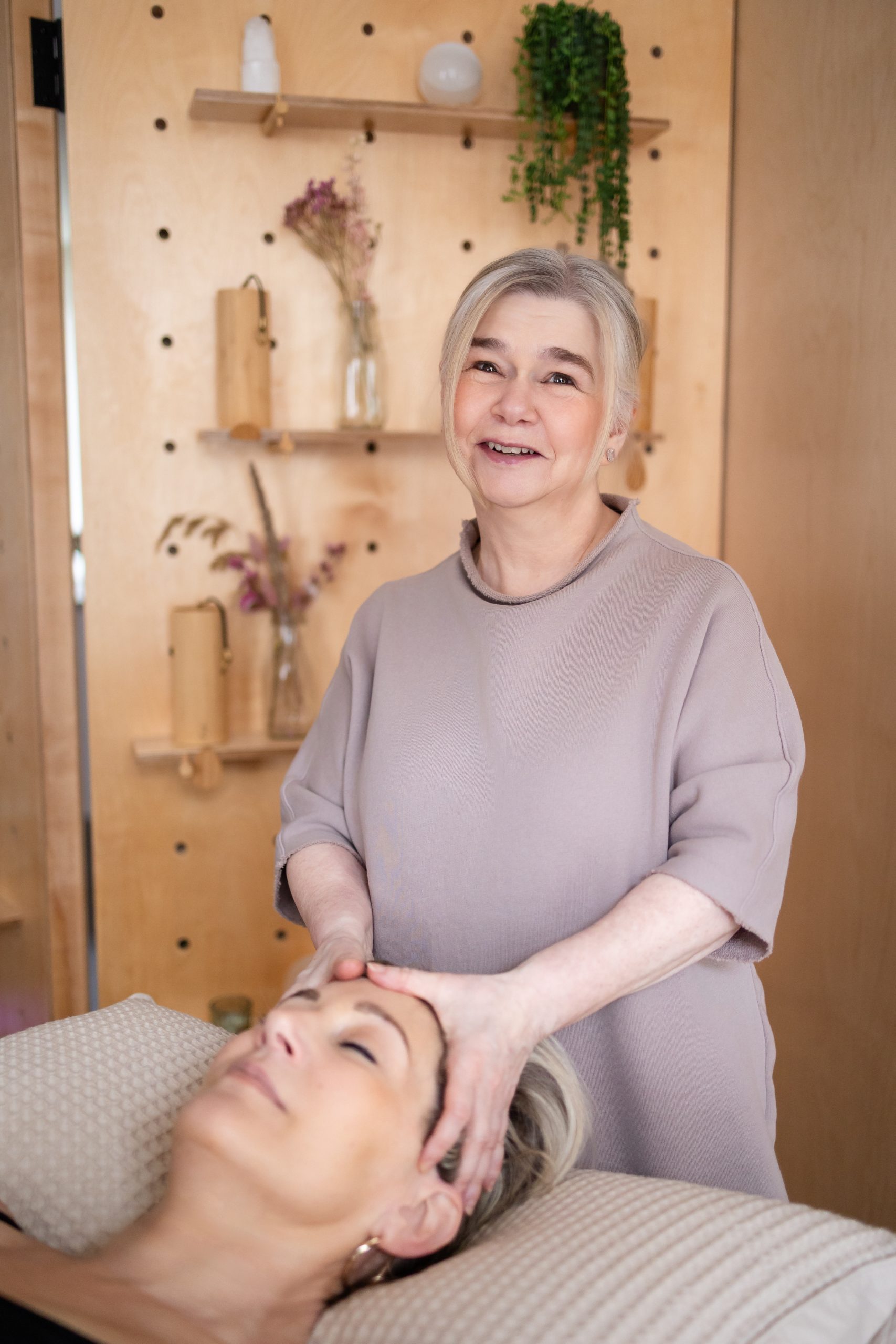 Woman receiving a relaxing head massage by a therapist indoors