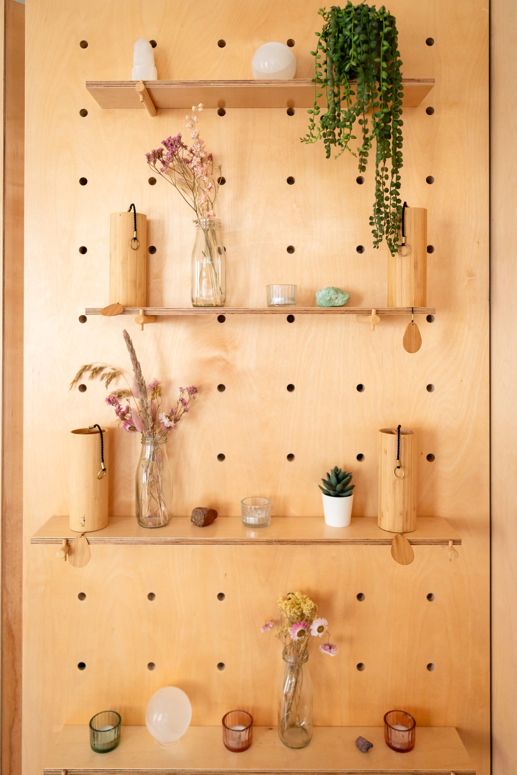 Wooden wall shelf with plants and decorative glass vases