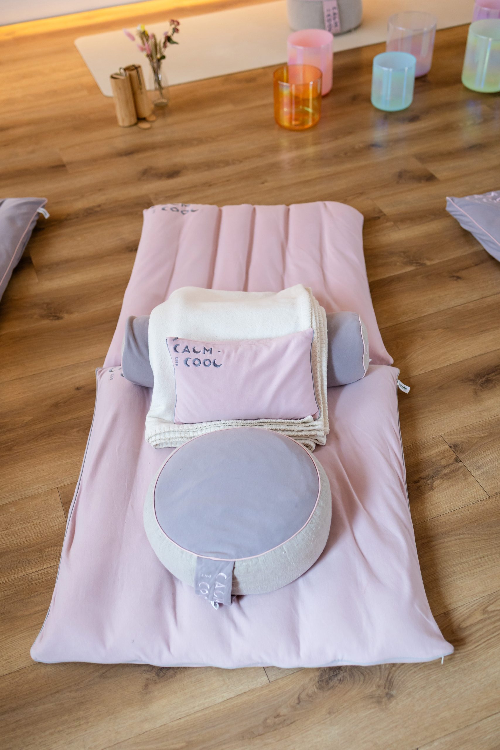 Meditation setup on wooden floor with cushions and blankets
