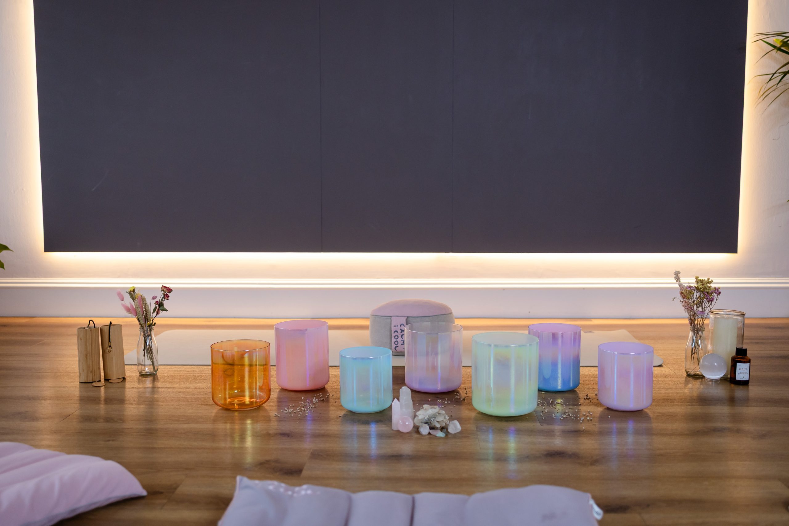 Colorful sound healing bowls on a serene meditation space floor