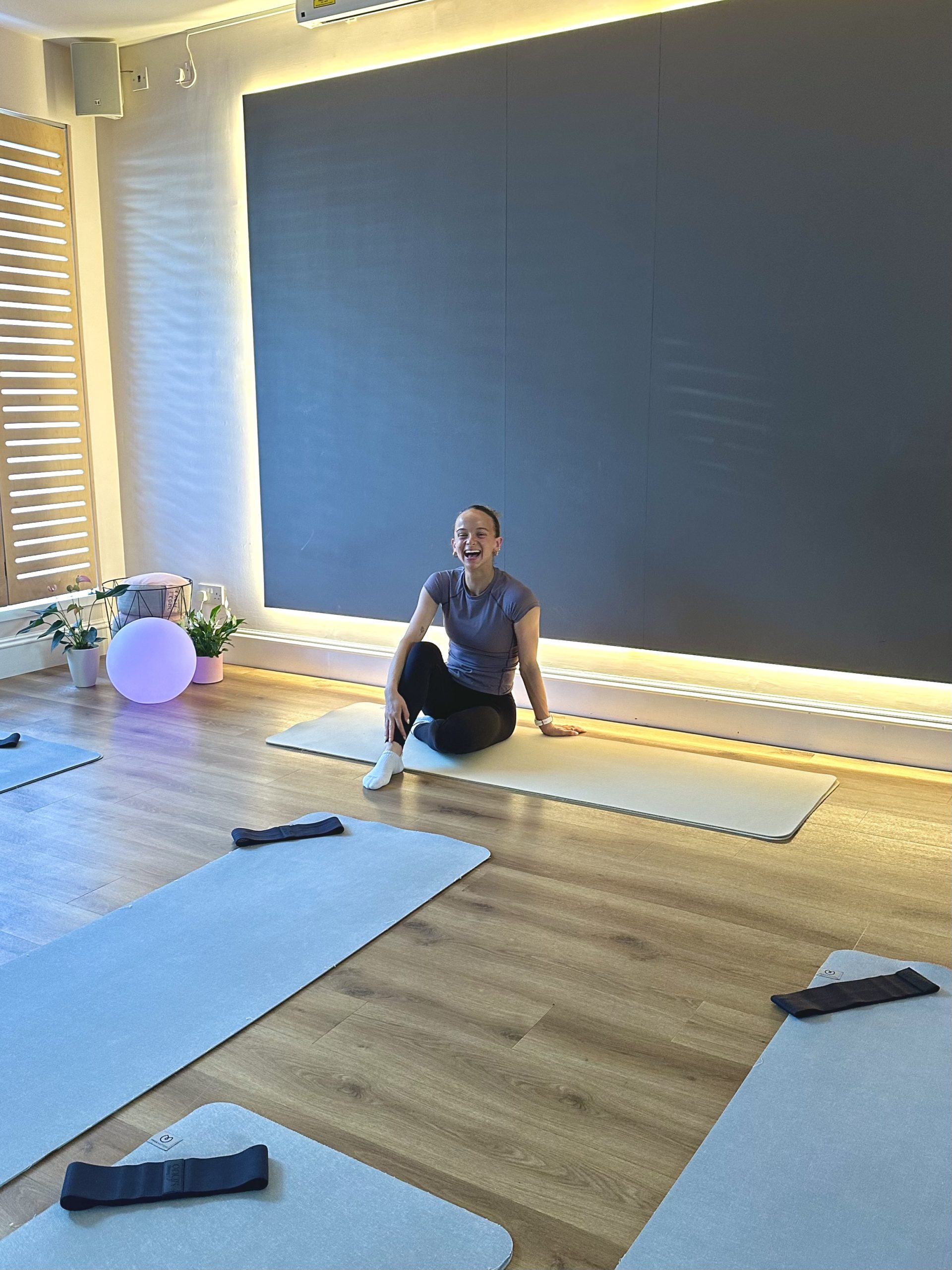 Woman smiling during a yoga session in a modern studio