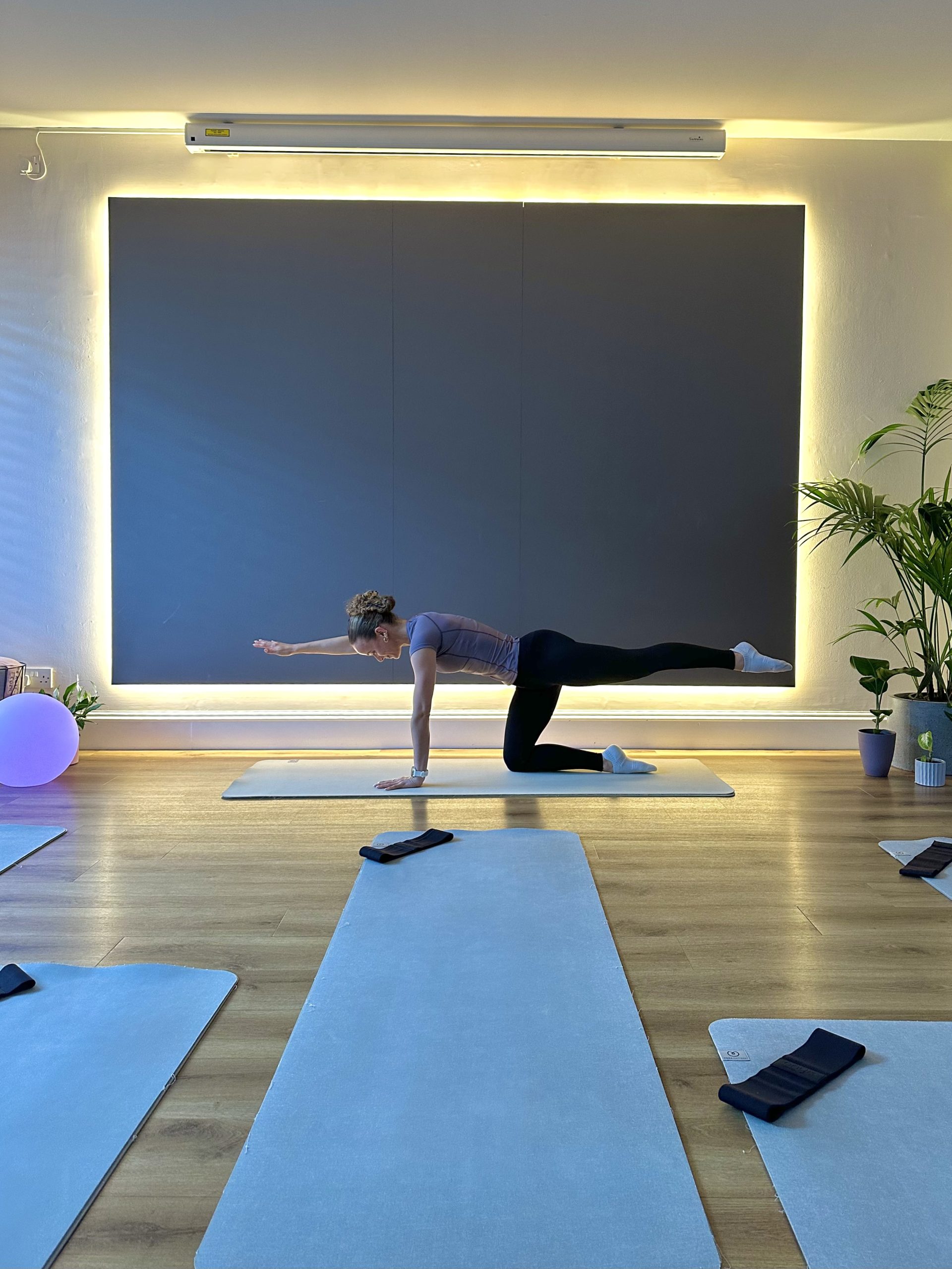 Person practicing yoga pose on a mat in a serene studio