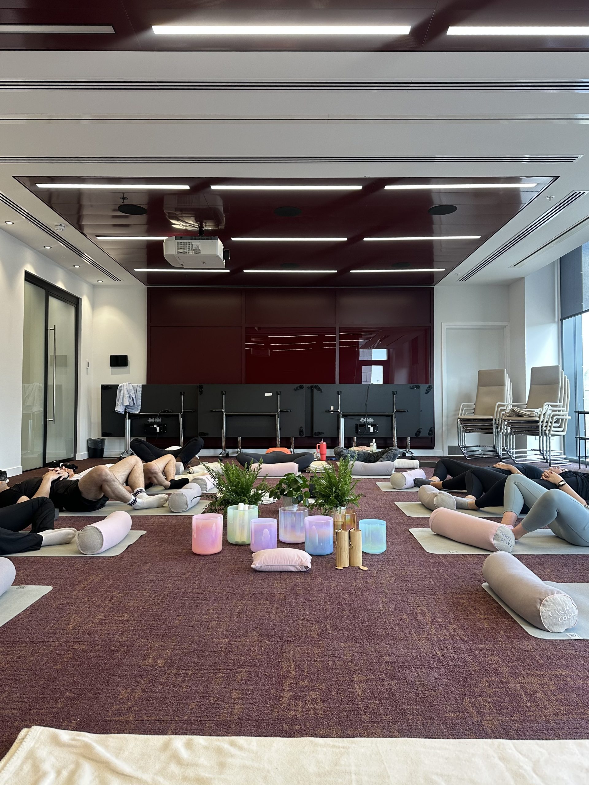 Group yoga class relaxing in a modern studio with mats and props