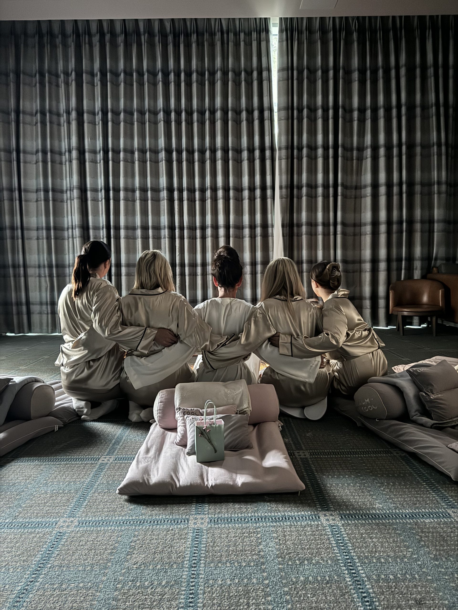 Five friends in robes hugging during relaxing spa day together