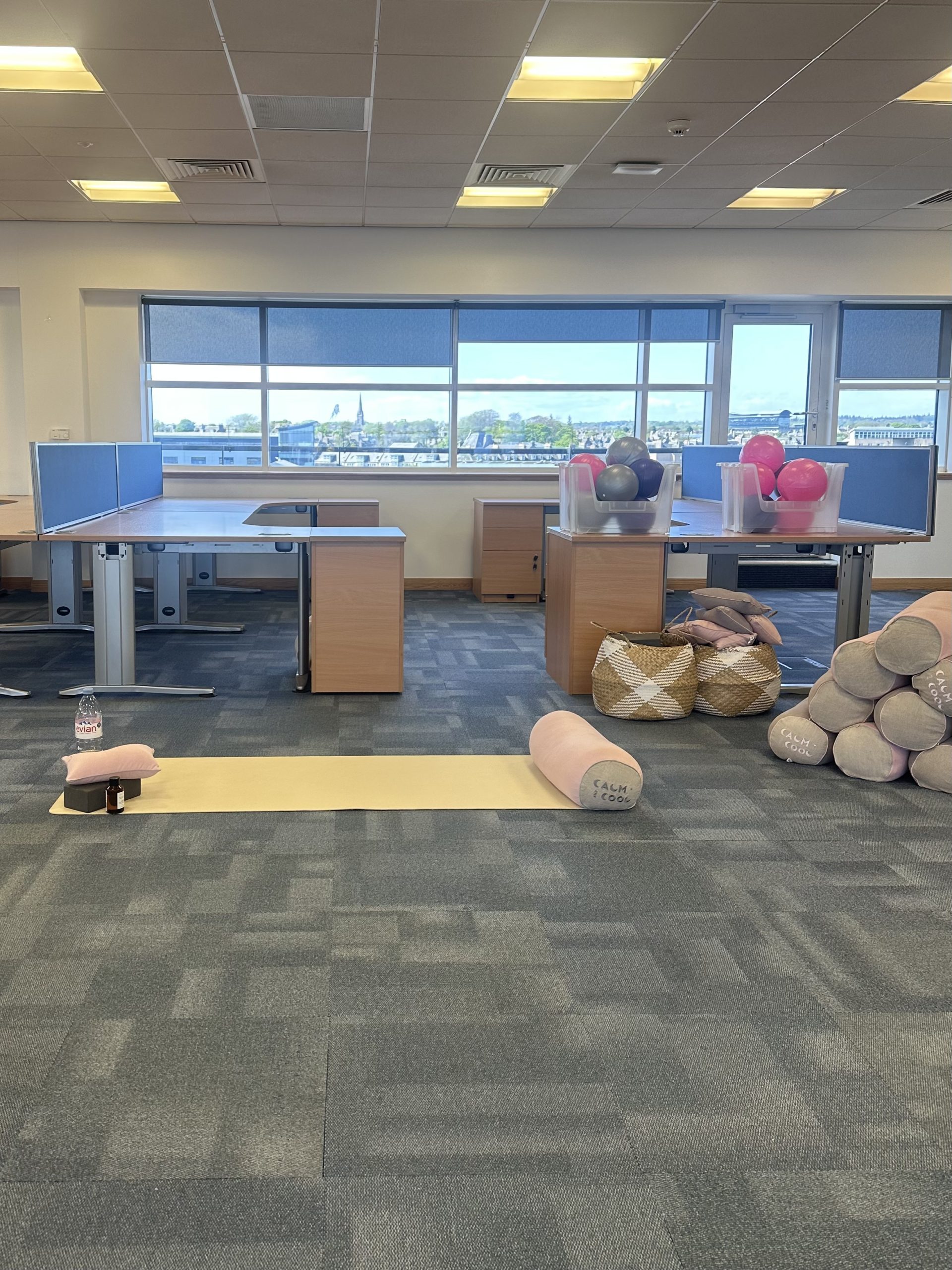 Office yoga setup with mats and balance balls near windows