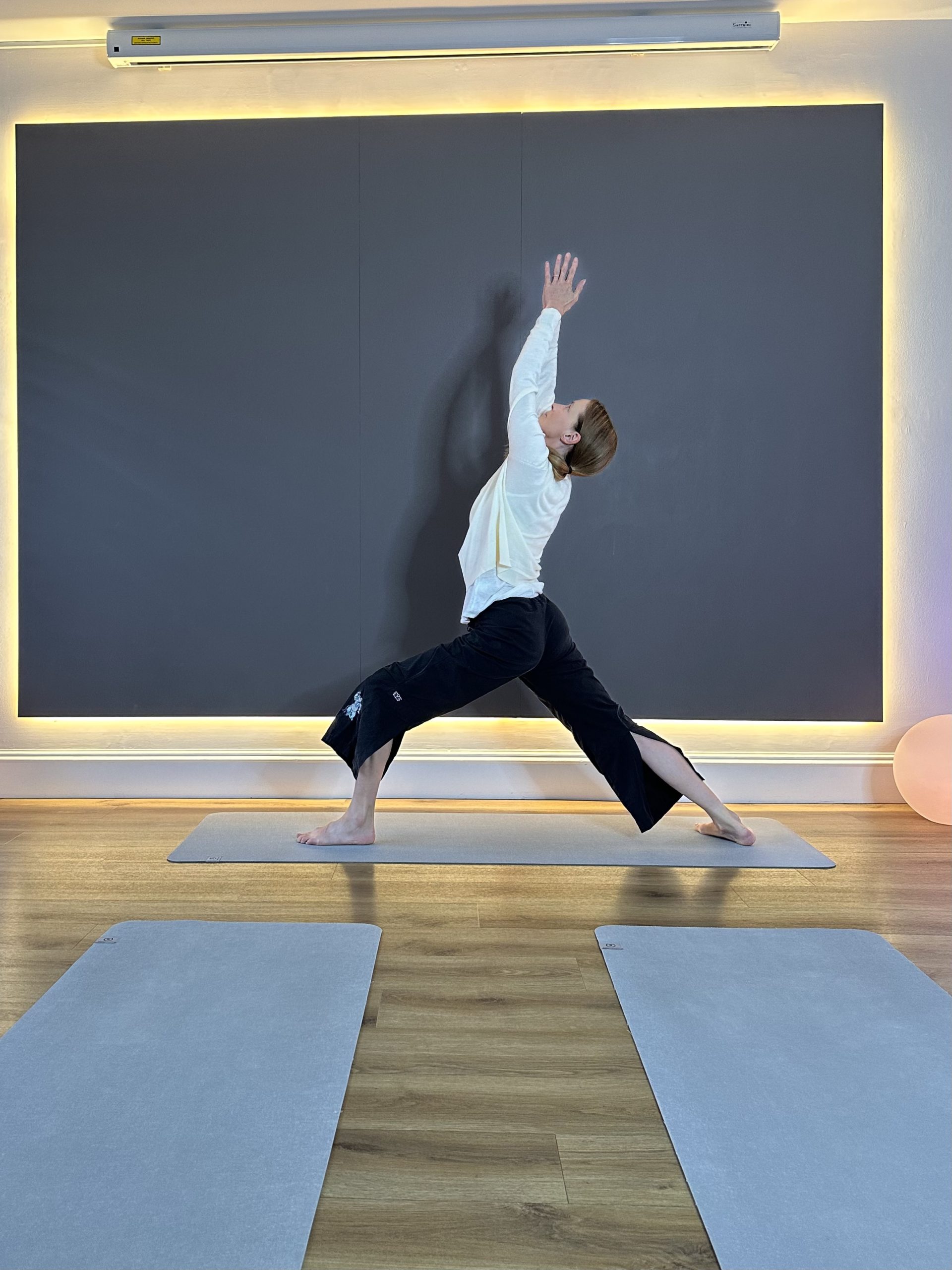 Person practicing yoga pose in a serene studio setting