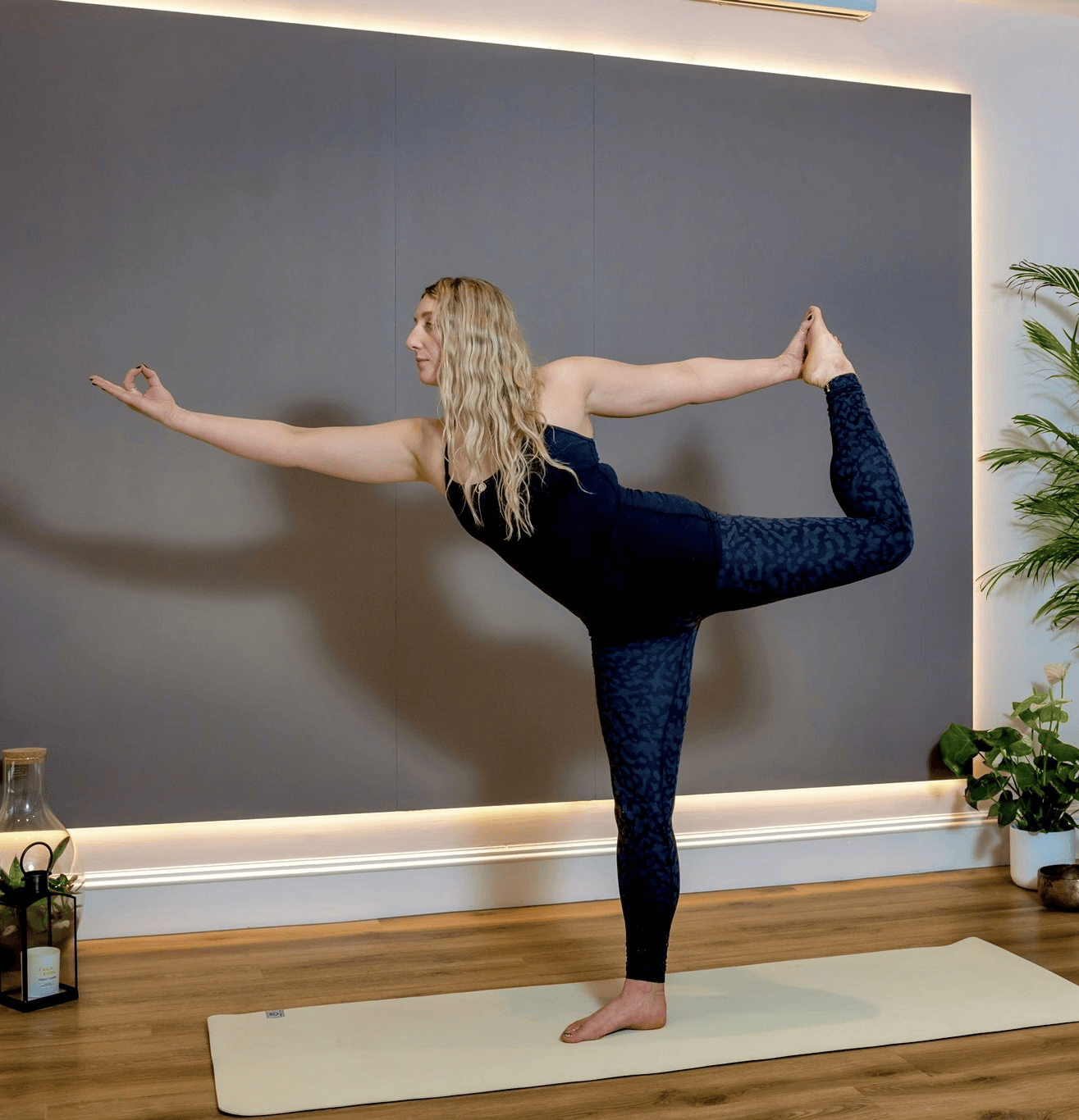Woman practicing standing yoga pose in a calm studio setting